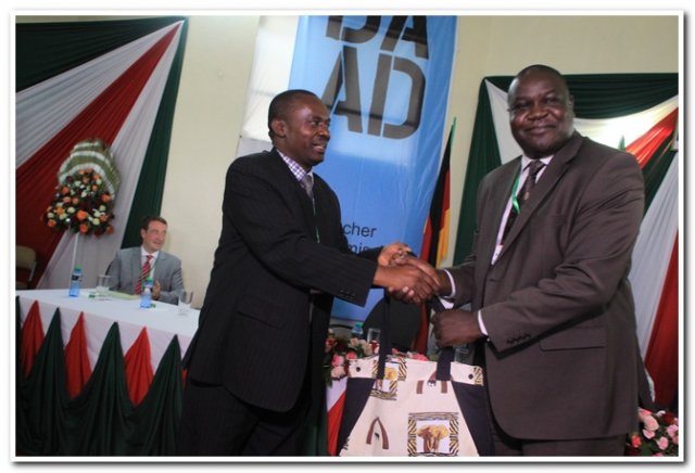 prof.kindiki handing over a present to ceo kie
